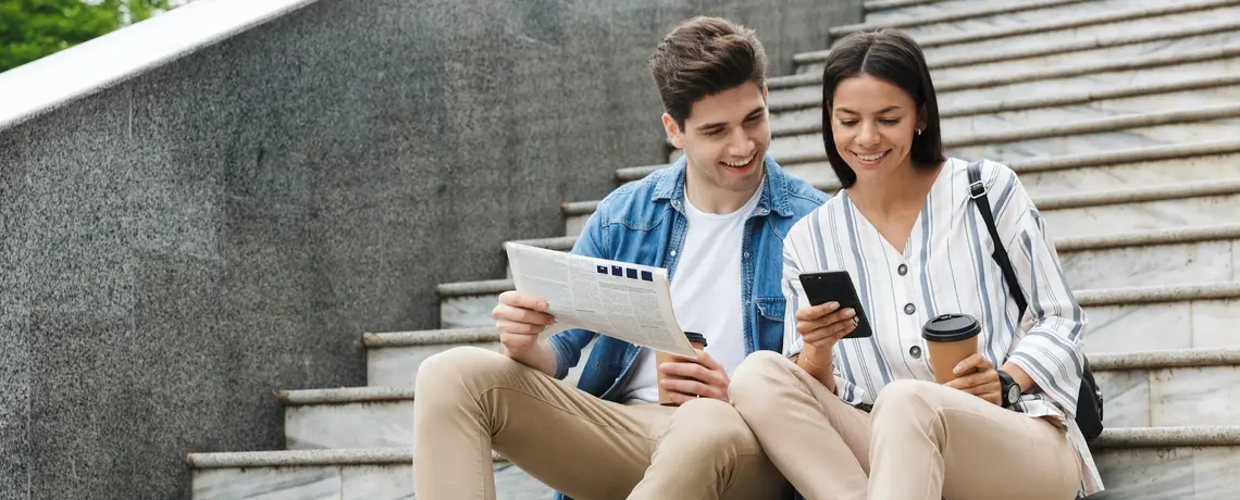 Junges Paar liest gedruckte Zeitung & noz Premium